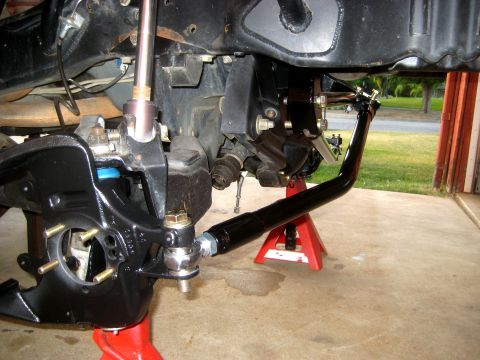 1996 Ford Bronco - Close-up view of vehicle steering and suspension components, supported by red jack stands.