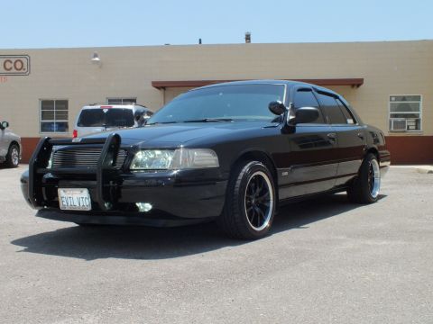 2003 Ford Crown Victoria - Lowered black four-door with chrome billet grille and EVIL VIC license plate.