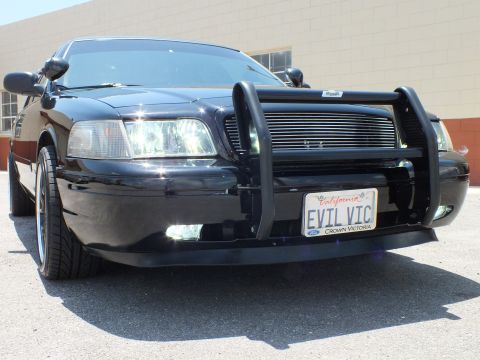 2003 Ford Crown Victoria - Low front-quarter of a black Crown Victoria with push bar and EVIL VIC plate.