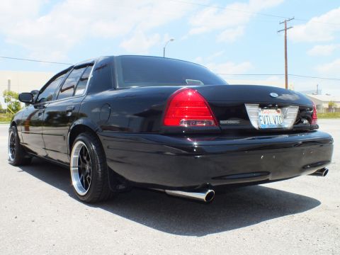 2003 Ford Crown Victoria - Rear quarter of a black Crown Victoria showing taillights, dual tips and EVIL VIC plate.
