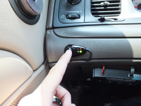 2003 Ford Crown Victoria - Hand activating an installed dash switch showing red and green indicator lights.