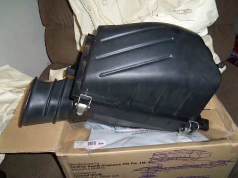 2000 Mercury Grand Marquis - Air intake housing part shown in a cardboard box, with some packaging material visible.