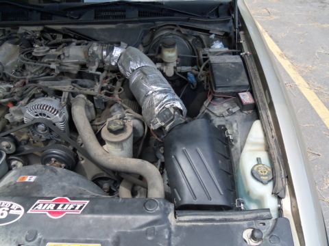 2000 Mercury Grand Marquis - The engine bay shows a custom intake tube and an Air Lift sticker, suggesting modifications.