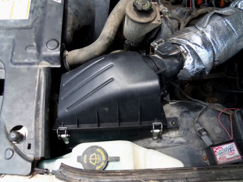 2000 Mercury Grand Marquis - Close-up view of the engine bay, focusing on the air intake system and associated components.