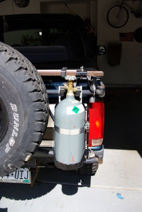 1995 Ford Bronco - The rear of a 1995 Ford Bronco is shown, a spare tire and a mounted propane tank.