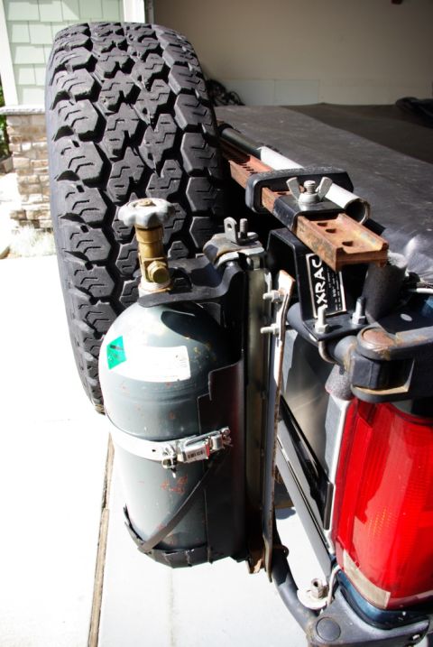 1995 Ford Bronco - Spare tire and fuel tank assembly attached to the rear of an unidentified vehicle.