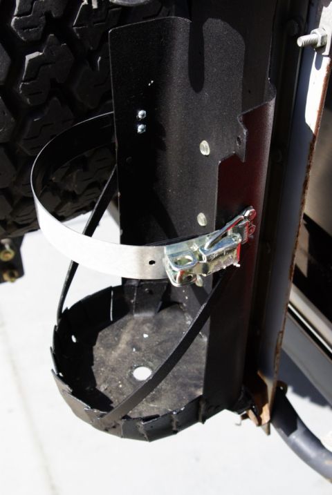 1995 Ford Bronco - Fire extinguisher mount assembly shown attached to a vehicle's tire carrier.