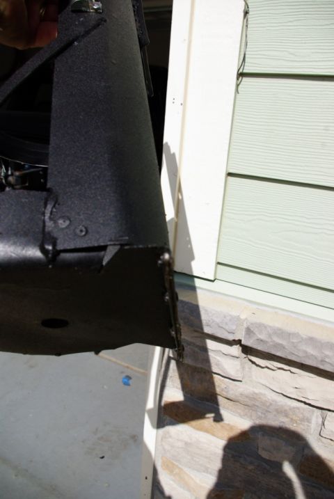 1995 Ford Bronco - A black metal part is shown in detail, attached to a building's exterior wall.