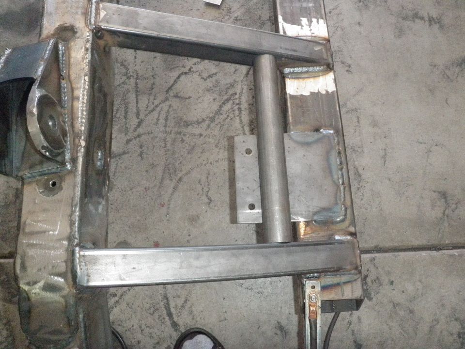 Close-up of a metal frame with welds and a cylindrical tube attached