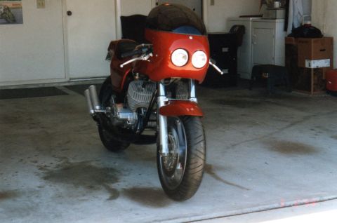 1999 Ford Ranger - A red motorcycle with a fairing and dual headlights is parked inside a garage.