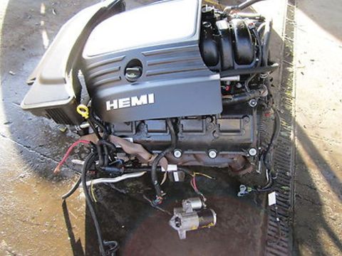 1999 Ford Ranger - A detached engine assembly, identified by its HEMI branding, sits with its starter motor and wiring exposed.