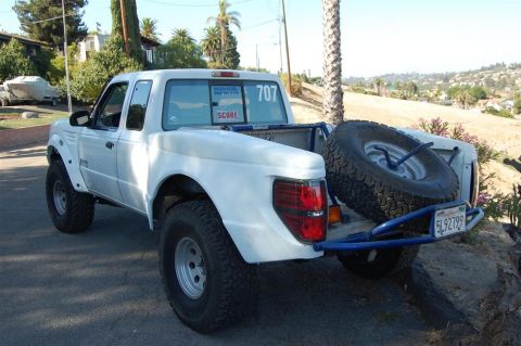 1999 Ford Ranger - white Ford Ranger desert prerunner truck with race number 707, SCORE sticker and a rear bumper-mounted spare tire.