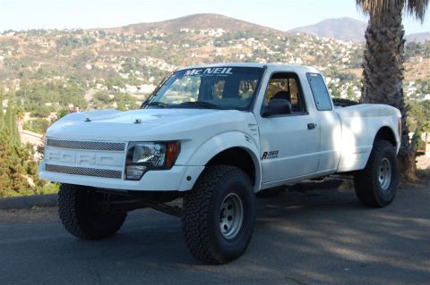 1999 Ford Ranger - A white Ford Ranger pickup truck is seen from a three-quarter front angle, with a custom grille and large tires.