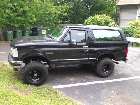1995 Ford Bronco - This black 1995 Ford Bronco features a lifted suspension and is shown from the side.