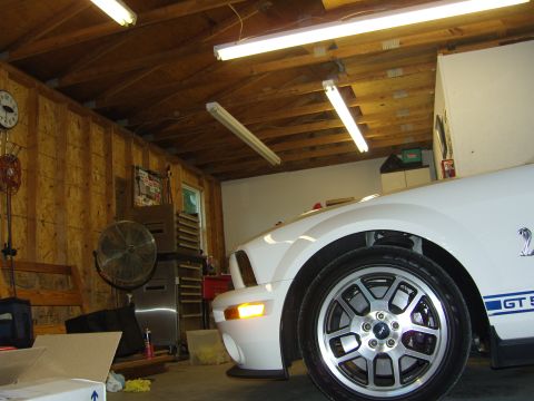 2007 Ford Mustang - A white Ford Mustang with GT500 stripes is parked in a garage.