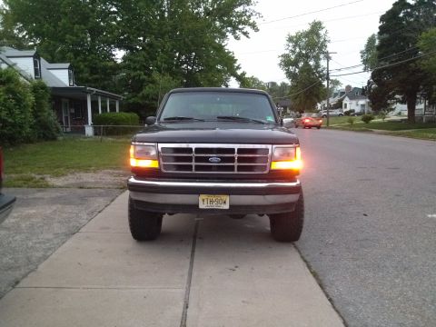 1995 Ford Bronco - Front view of a black 1995 Ford Bronco parked on a residential street.