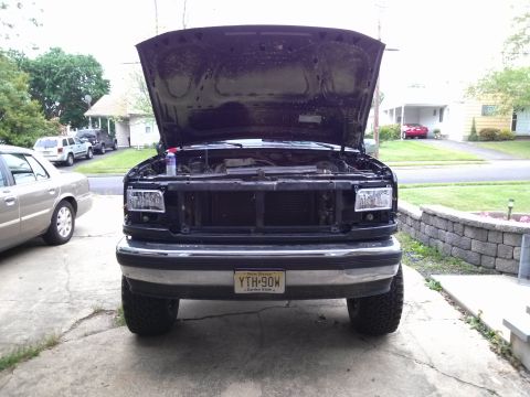 1995 Ford Bronco - Front view of a 1992-1997 Ford F-Series truck with its hood open, parked next to another vehicle.