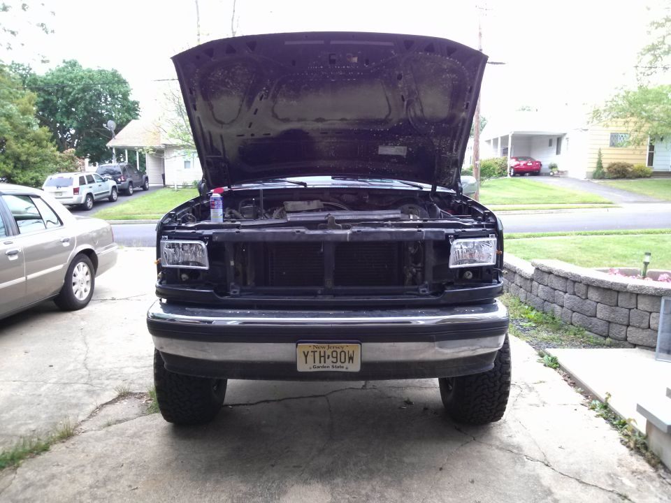1992-1997 Ford F-Series truck front view with hood open. Another car is parked to the left