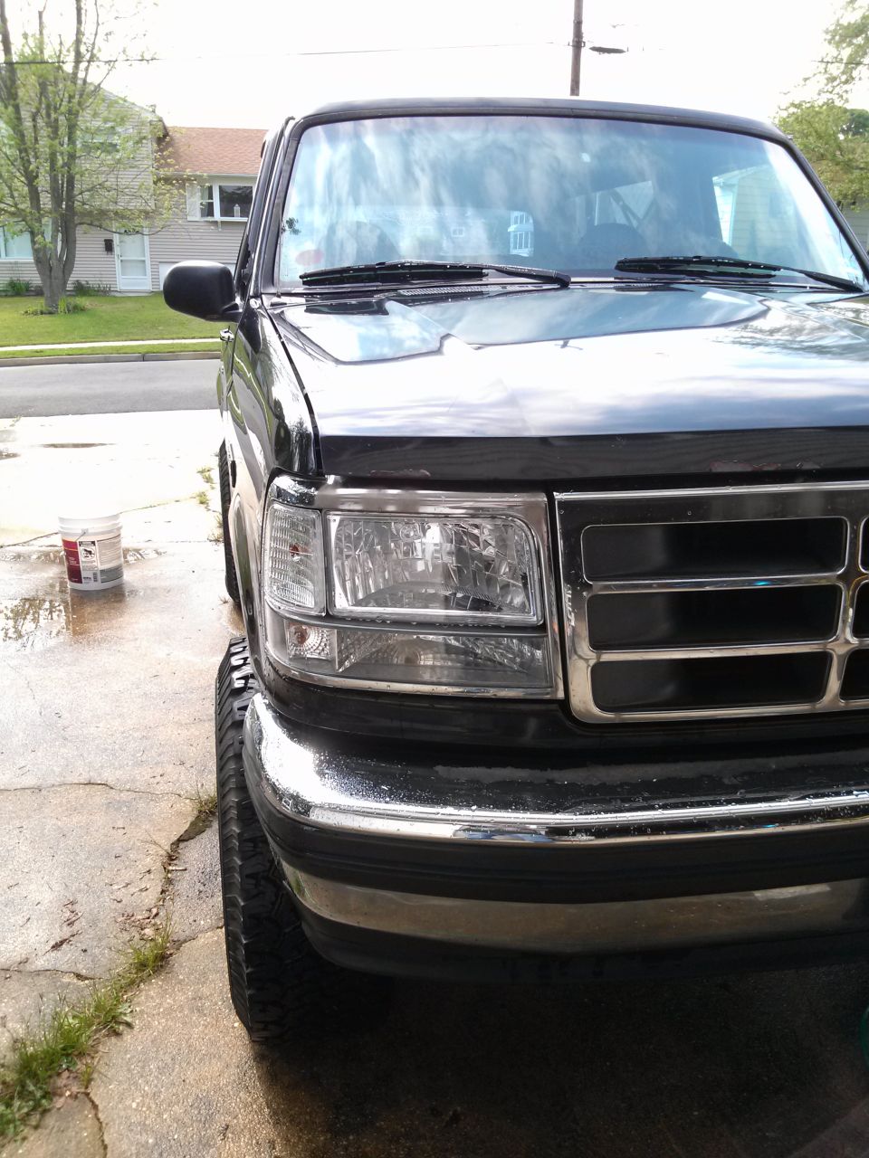 Black Ford Bronco, front quarter view, chrome grille and bumper, visible tire and headlight