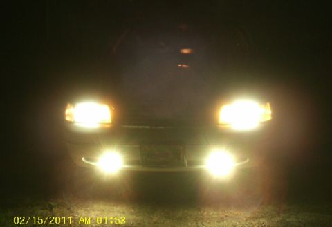 1998 Ford Crown Victoria - The front of a vehicle is illuminated by its headlights and fog lights in the dark.