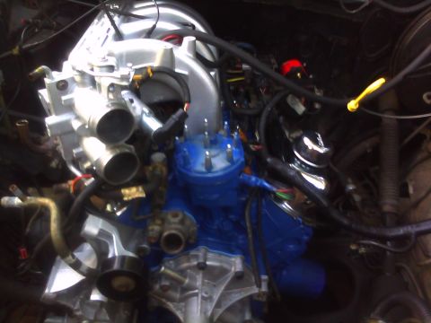 1993 Ford Bronco - Engine bay details with various hoses, wires, and metallic components visible.