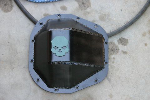 1991 Ford Bronco - A custom differential cover with a skull emblem is shown resting on a concrete surface.