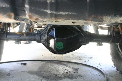 1991 Ford Bronco - Underside view of a vehicle's rear differential, a black cover with a green skull decal.