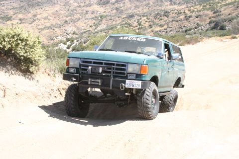 1991 Ford Bronco - This lifted 1991 Ford Bronco navigates a sandy incline, its off-road capabilities.