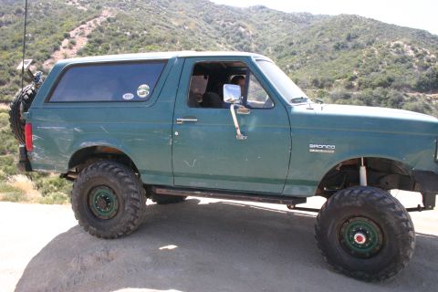 1991 Ford Bronco - This 1991 Ford Bronco is shown off-road with a spare tire on the rear and large tires for rough terrain.