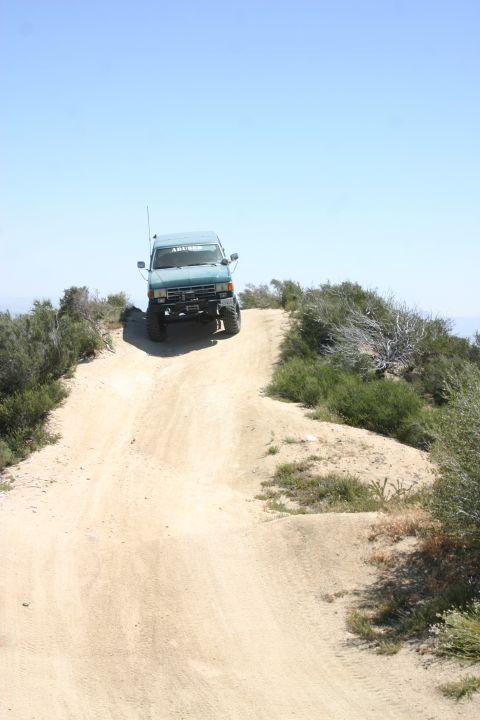 1991 Ford Bronco - 1991 Ford Bronco navigating an off-road trail on a sunny day.