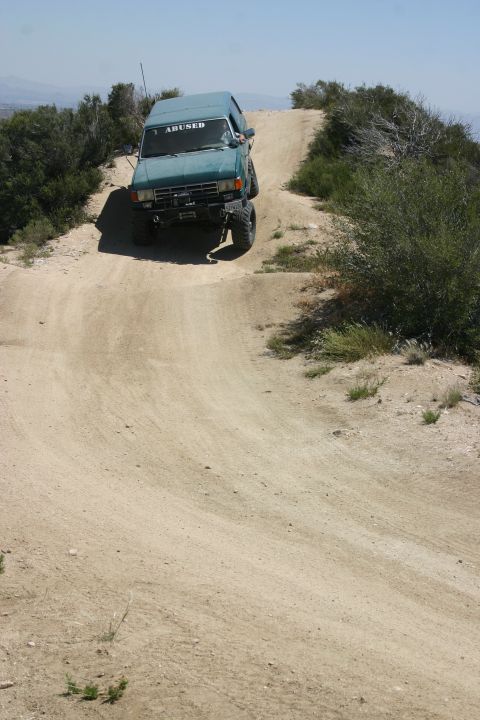 1991 Ford Bronco - Teal 1991 Ford Bronco navigates a challenging dirt trail on a sunny day.