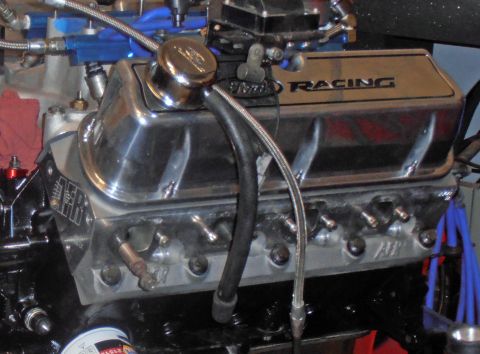 1990 Ford Bronco - A chrome valve cover with "RACING" text is the main focus, with various engine components in the background.