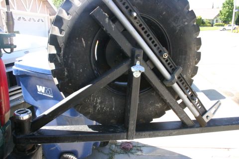 1991 Ford Bronco - Aftermarket spare tire carrier mounted to a vehicle, a hi-lift jack and a bottle opener.
