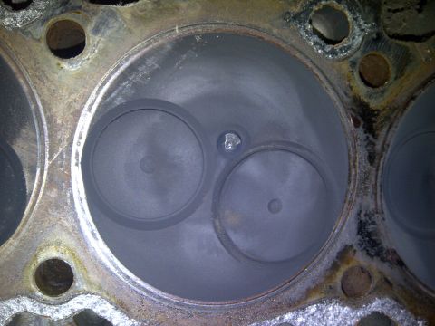 1986 Ford Bronco - Close-up view of an engine cylinder head, showing two valves and carbon buildup.