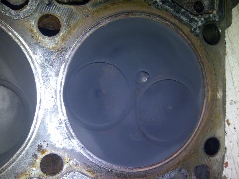1986 Ford Bronco - Close-up of an engine cylinder head, revealing two valves and significant carbon deposits.