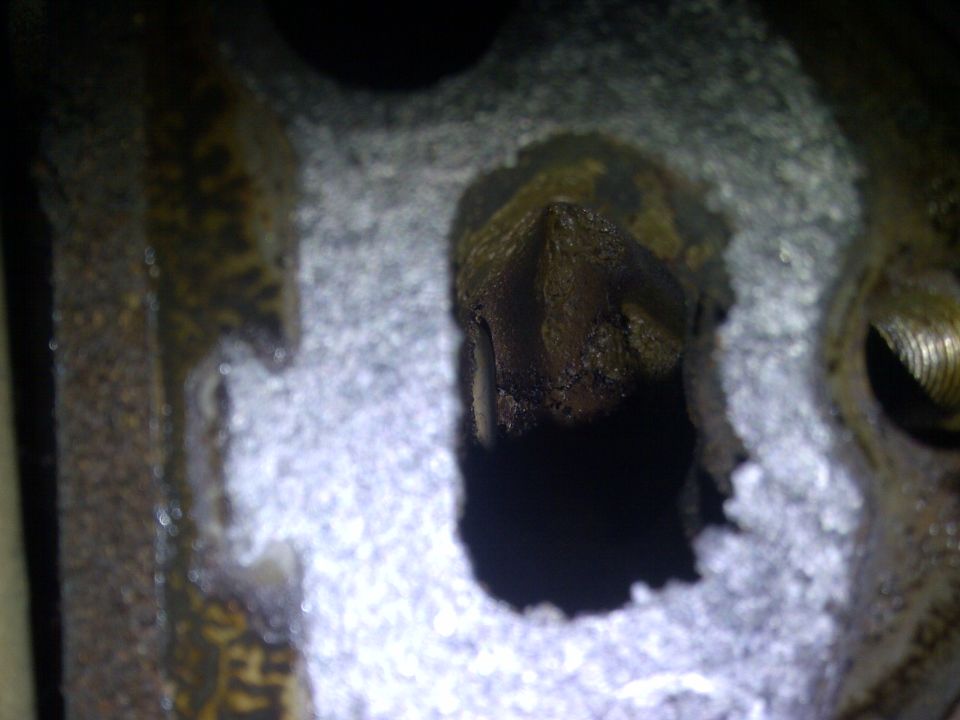 Close-up of a dirty engine part with a pointed protrusion