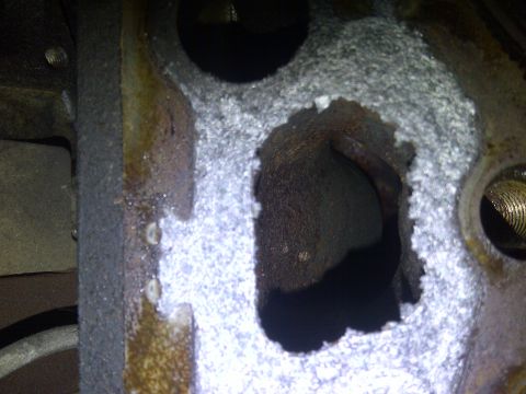 1986 Ford Bronco - Corrosion and damage are visible on this engine cylinder head, obscuring any model year details.