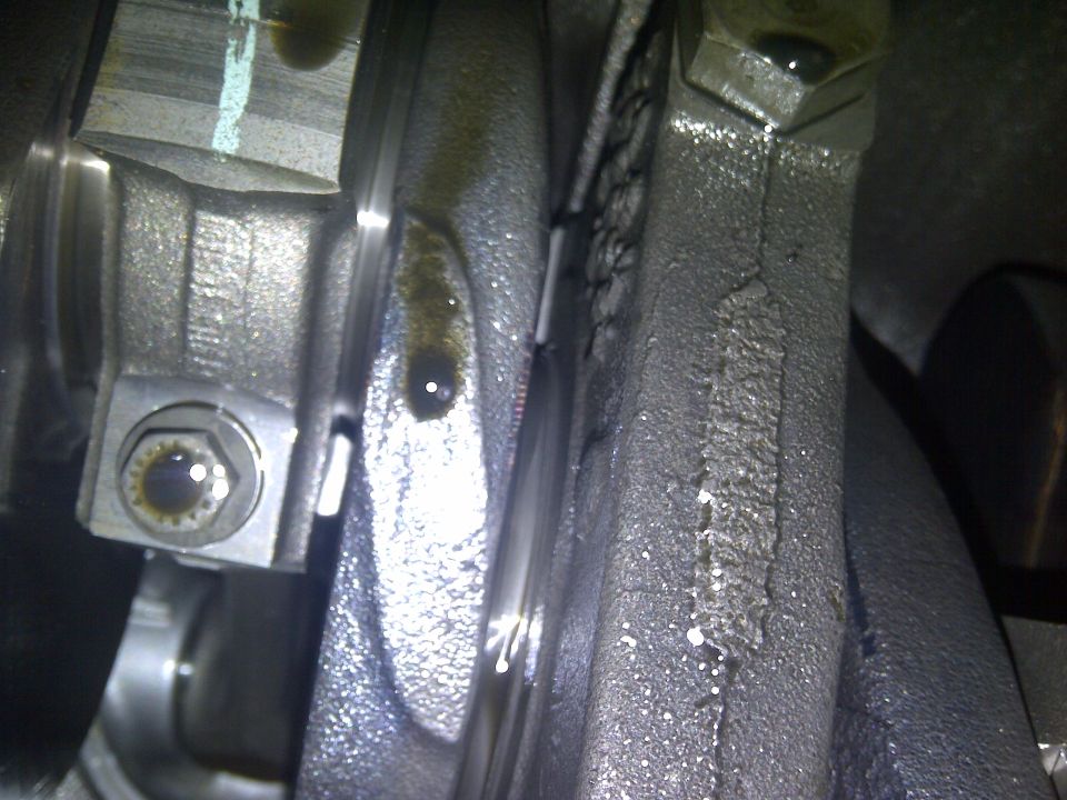 Close-up of engine crankshaft and connecting rod with oil