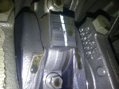 1986 Ford Bronco - This is a close-up view of an engine's connecting rod bearing, showing wear and a white marking.