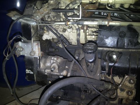 1986 Ford Bronco - Close-up view of an engine compartment, showing mechanical components and a power steering reservoir.