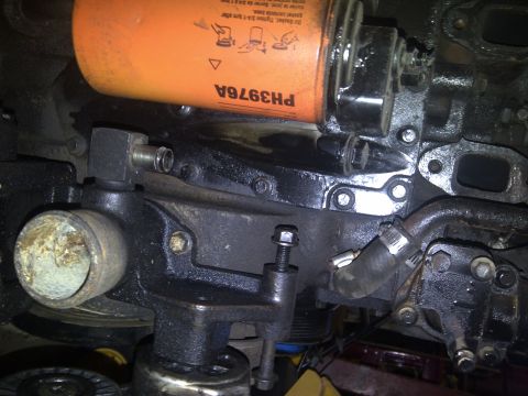 1986 Ford Bronco - Close-up of an engine component an oil filter and various hoses and fittings.