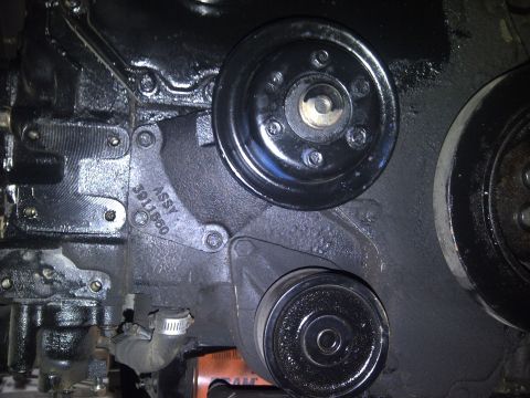 1986 Ford Bronco - Close-up view of an engine block with stamped assembly number and visible pulleys.