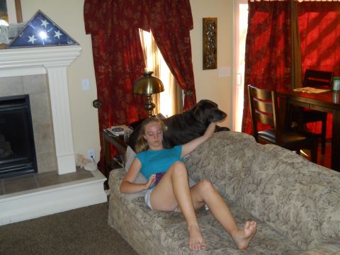 1976 Ford Bronco - A girl and her dog relax on a couch in a living room setting.