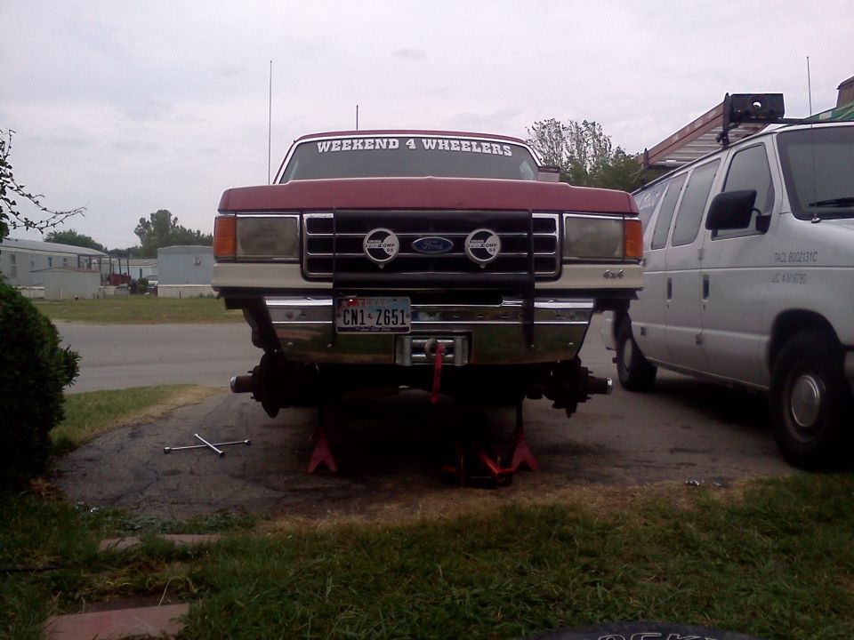 1989 Ford Bronco front view on jack stands, red with "WEEKEND 4 WHEELERS" sticker