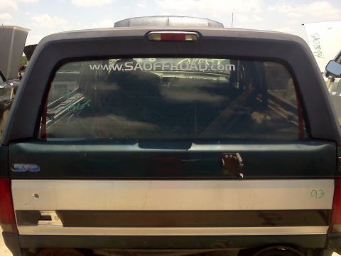 1989 Ford Bronco - Rear view of a 1989 Ford Bronco with a camper shell and a website sticker on the rear window.