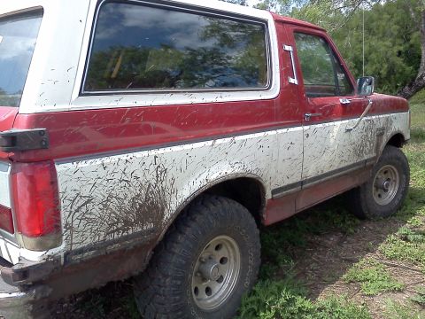 1989 Ford Bronco - This 1989 Ford Bronco is seen from the side, coated in mud from off-road use.