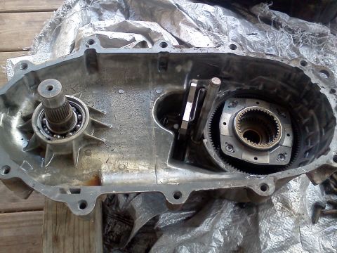 1989 Ford Bronco - Close-up of the internal components of a vehicle's transfer case, showing gears and a bearing assembly.