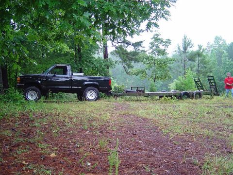 1989 Ford Ranger - A black 1989 Ford Ranger is parked on a grassy area, hitched to a trailer, with a person standing nearby.