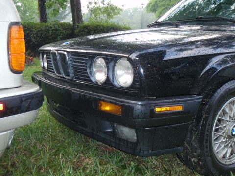 1991 BMW 3 Series - A black 1991 BMW 3 Series is seen from the front, with water droplets on its surface.