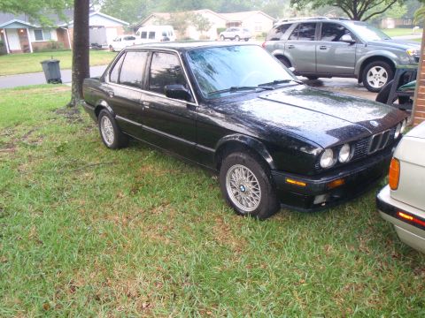 1991 BMW 3 Series - A black 1991 BMW 3 Series sedan is parked on a grassy lawn next to another vehicle.